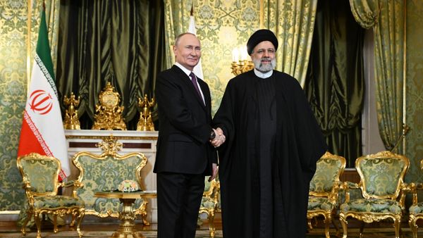 Russian President Vladimir Putin and Iranian President Ebrahim Raisi shake hands as they pose for a photo before a meeting at the Kremlin - Sputnik International