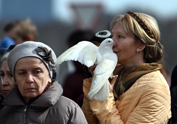 A woman holds a white dove during a requiem liturgy for the victims of the terrorist attack at Crocus City Hall. - Sputnik International