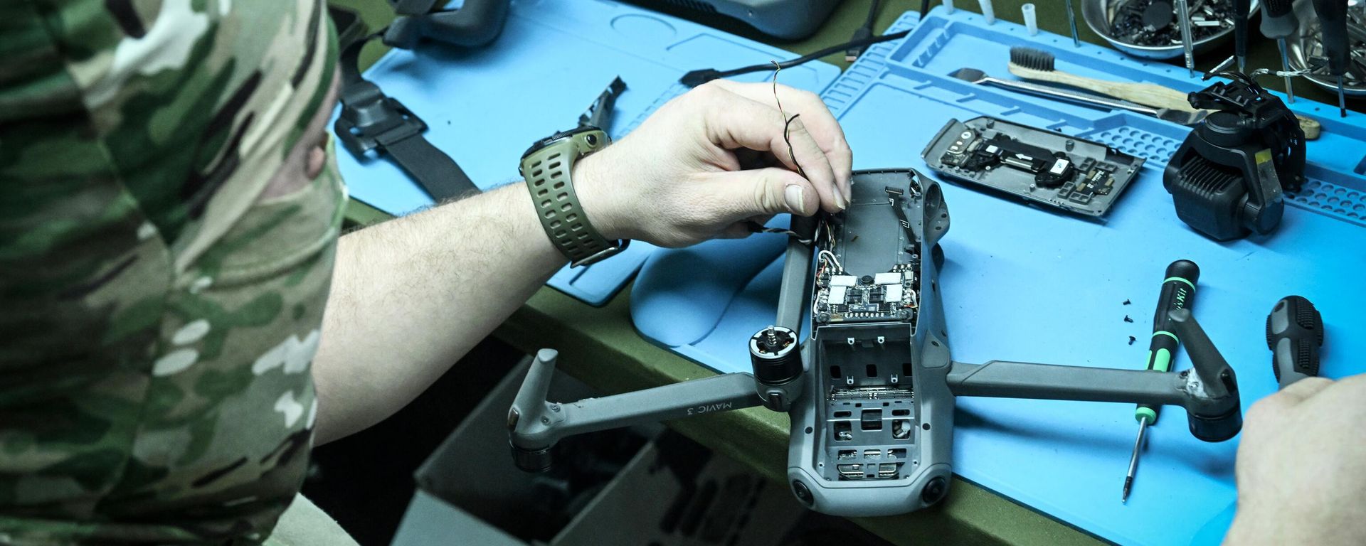 A serviceman of the Russian Armed Forces works on a captured Ukrainian drone to learn the useful data. - Sputnik International, 1920, 31.03.2024