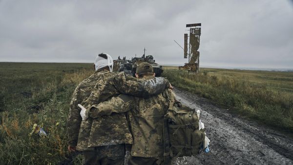 A Ukrainian soldier helps a wounded fellow. File photo - Sputnik International