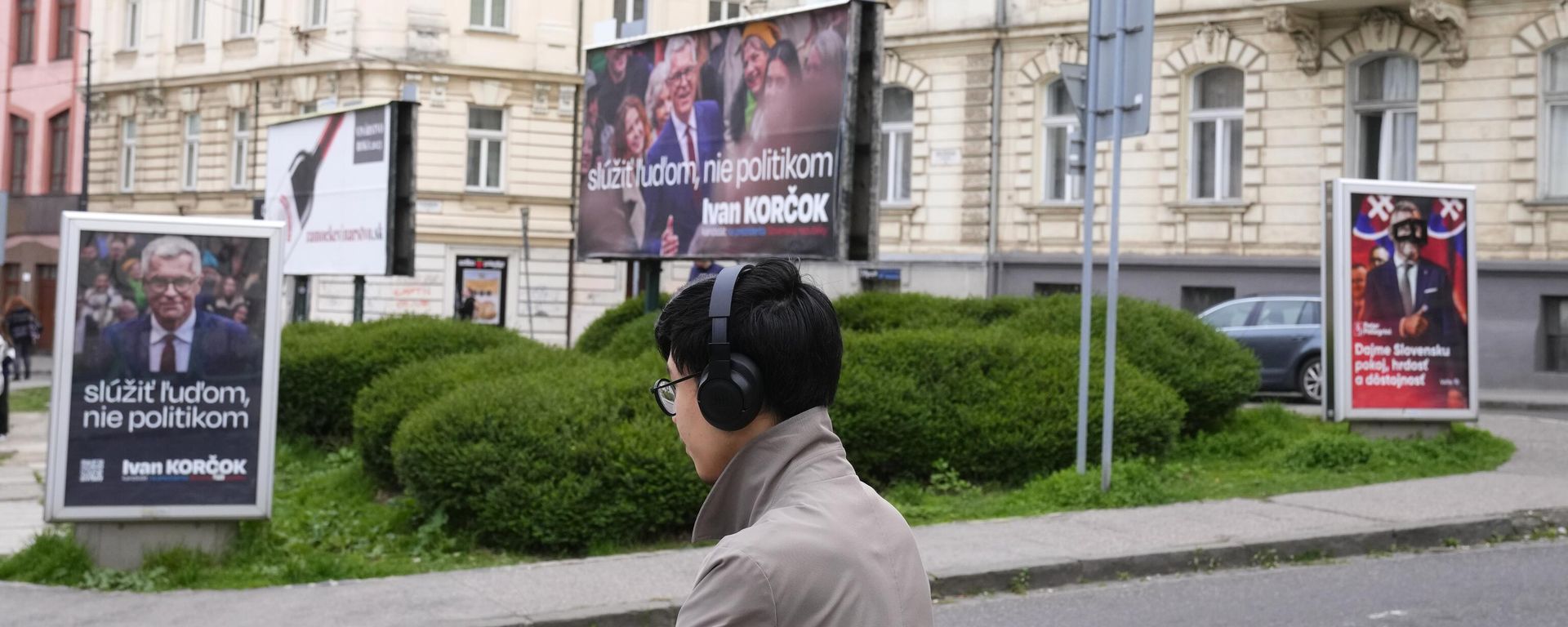 A man stands by posters for former Foreign Minister Ivan Korcok, a pro-Western career diplomat, and Peter Pellegrini, right, who currently serves as Parliament's speaker, two of the nine candidates in the upcoming Slovakia's presidential election, in Bratislava, Slovakia, Friday, March 22, 2024. (AP Photo/Petr David Josek) - Sputnik International, 1920, 06.04.2024