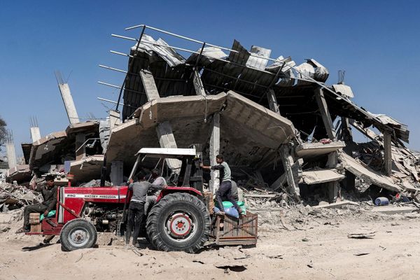People on a tractor pick up salvaged items from a collapsed building. - Sputnik International