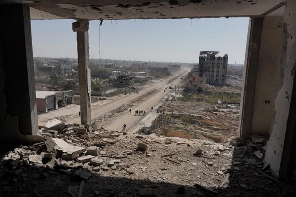 People walk past the ravaged building of Al-Salam Hospital in Khan Yunis after Israel pulled its ground forces out of the southern Gaza Strip. - Sputnik International