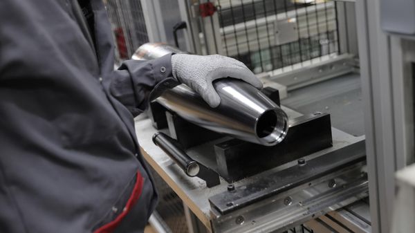 An employee puts his hand on a huge bullet being made as French President Emmanuel Macron visits the Nexter Arrowtech facility  - Sputnik International