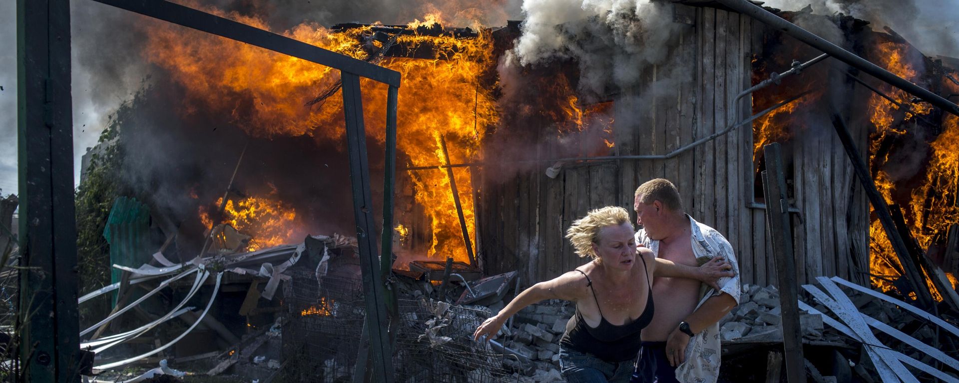 Local residents flee a fire caused by an air strike of the Ukrainian armed forces on a settlement in Lugansk region in 2014. - Sputnik International, 1920, 13.04.2024