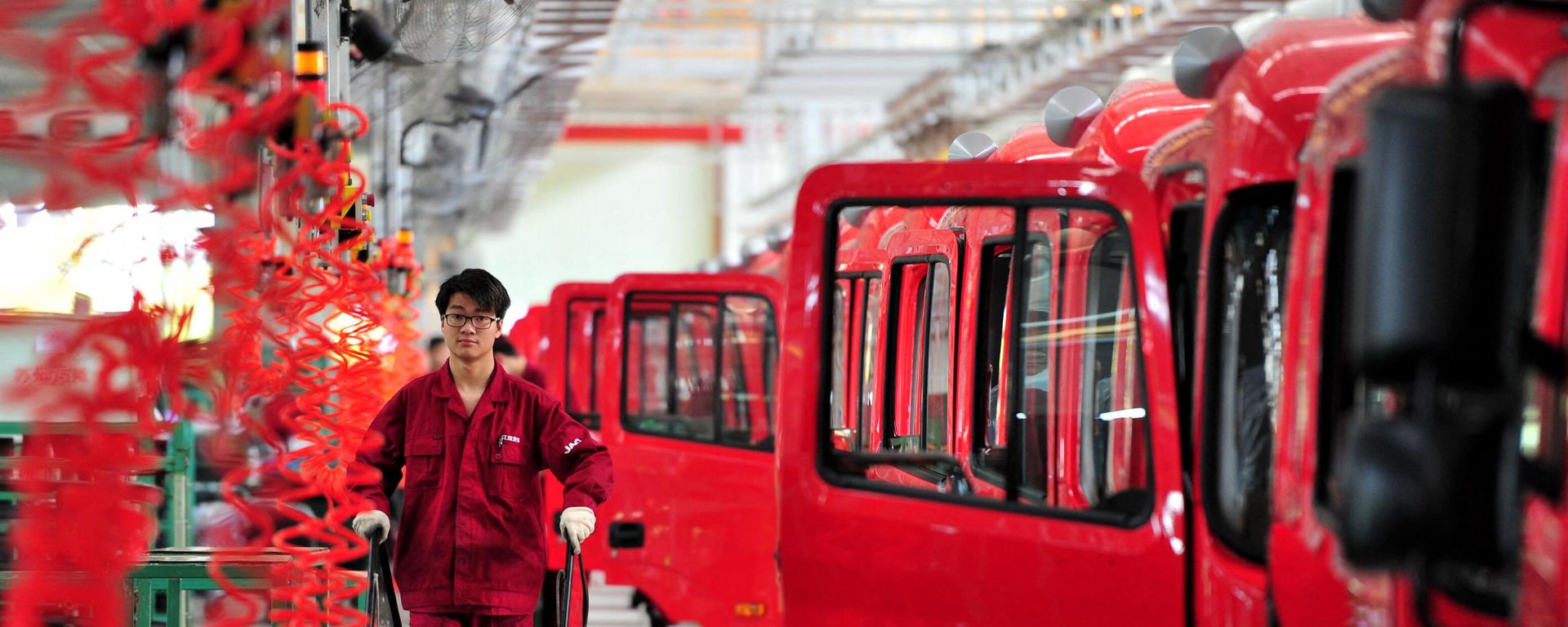 Chinese workers assemble trucks at an auto plant in Fuyang, Anhui province, located in China's east, on April 17, 2017.  - Sputnik International, 1920, 16.04.2024