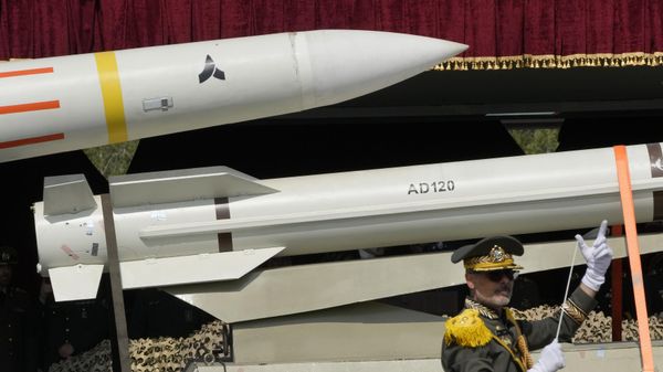 Missiles are carried on a truck as an Iranian army band leader conducts the music band during Army Day parade - Sputnik International