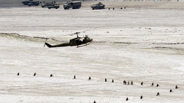 A Philippine Huey helicopter prepares to drop off troops while Philippine marines take positions in an assault simulation during the annual US-Philippine joint military exercise on May 15, 2014.  - Sputnik International