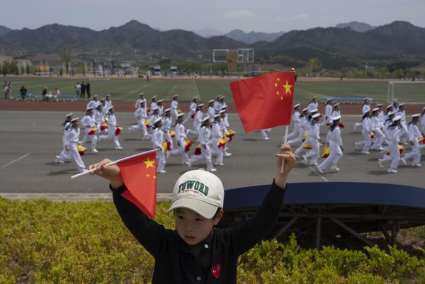 A child holds up Chinese national flags as sailors run past at the Chinese People's Liberation Army’s (PLA) naval submarine academy during a tour arranged for foreign journalists. - Sputnik International