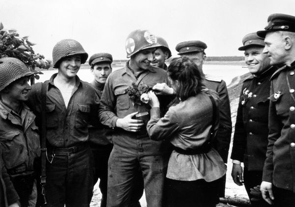 Soviet nurse Lyubov Kazichenko gives flowers to American soldier Carl Robinson. - Sputnik International