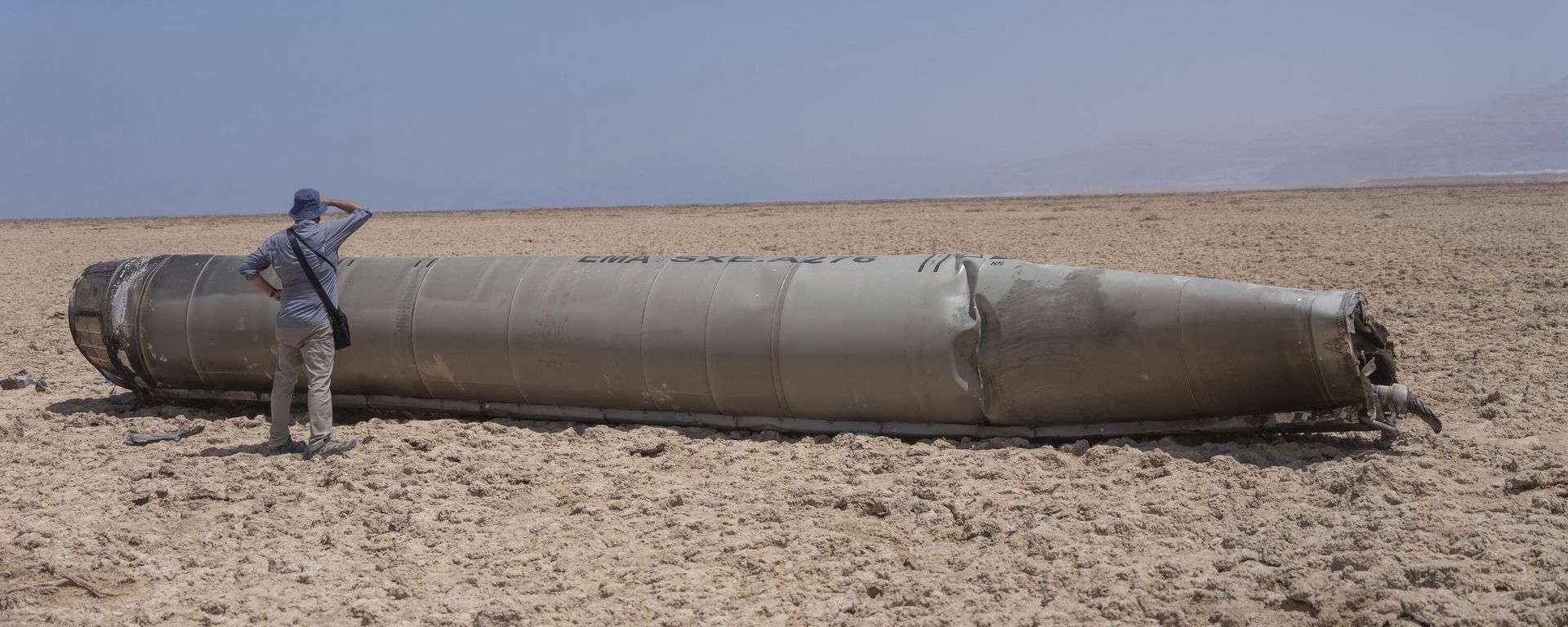 A photojournalist looks at part of the intercepted ballistic missile that fell near the Dead Sea - Sputnik International, 1920, 25.04.2024