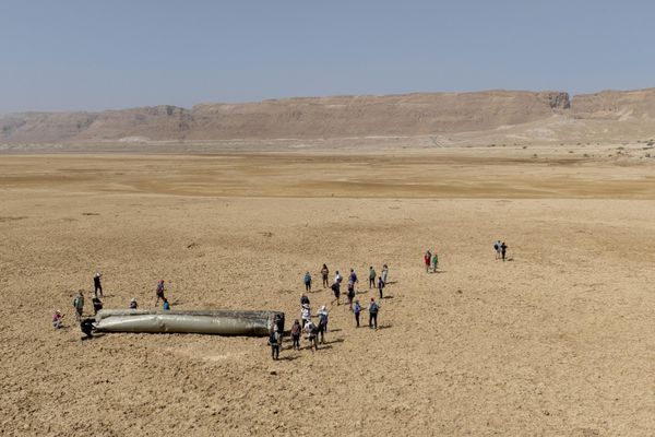 Locals gather around a component from an Iran's ballistic missile intercepted by Israeli air defenses. - Sputnik International