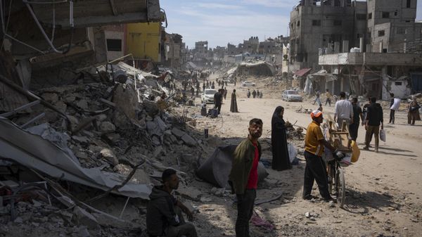 Palestinians walk through the destruction in the wake of an Israeli air and ground offensive in Khan Younis, southern Gaza Strip, Monday, April 8, 2024 - Sputnik International