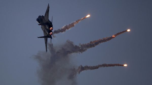 An Israeli Air Force fighter jet releases flares during an acrobatics display during a graduation ceremony in the Hatzerim air force base near the southern city of Beersheba, Israel, Thursday, Dec. 27, 2012 - Sputnik International