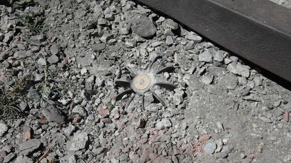 Tail end of an unexploded shell sticks out of the ground following artillery shelling in Aleksandrovka village in the Donetsk Region. - Sputnik International