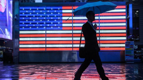 Pedestrians shelter beneath umbrella as they walk along a street during rain in Times Square, New York on September 26, 2023.  - Sputnik International