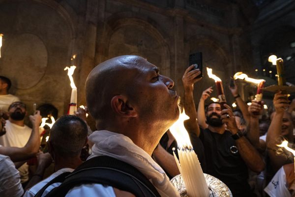 Orthodox Christians gather with lit candles during the Holy Fire ceremony at the Holy Sepulchre Church in Jerusalem's Old City on the eve of Easter Sunday. - Sputnik International