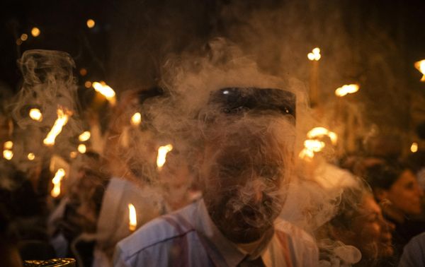Orthodox Christians gather with lit candles during the Holy Fire ceremony at the Holy Sepulchre Church in Jerusalem's Old City on the eve of Easter Sunday. - Sputnik International