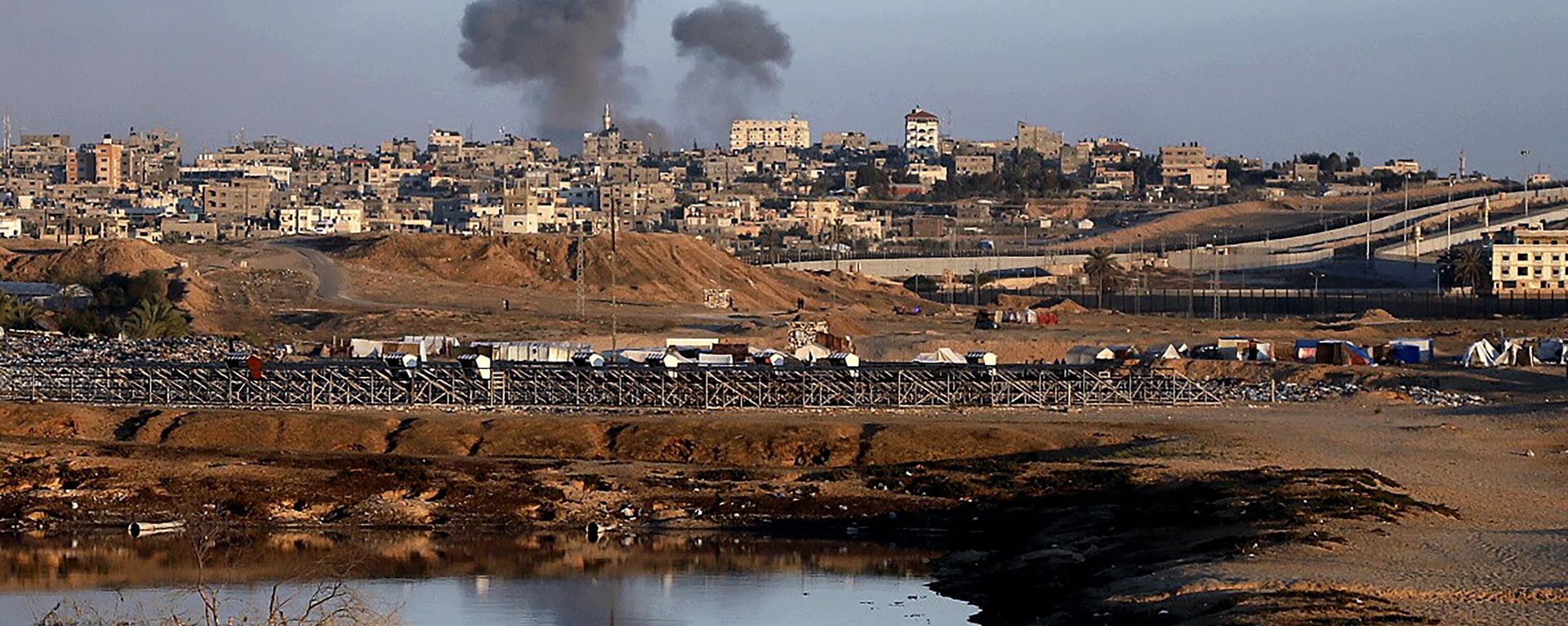 Smoke rises following an Israeli airstrike on buildings near the separating wall between Egypt and Rafah, southern Gaza Strip, Monday, May 6, 2024.  - Sputnik International, 1920, 04.07.2024