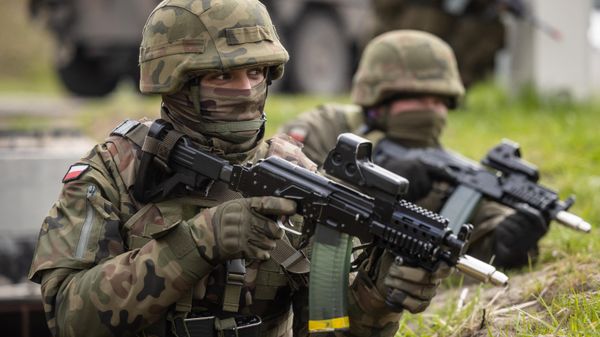 Polish soldiers take up positions during military drills of Polish and NATO soldiers near the Vistula Spit canal, near Krynica Morska, northern Poland on April 17, 2023.  - Sputnik International