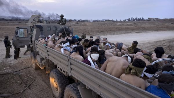 Israeli soldiers stand by a truck packed with bound and blindfolded Palestinian detainees, in Gaza, Friday, Dec. 8, 2023. - Sputnik International