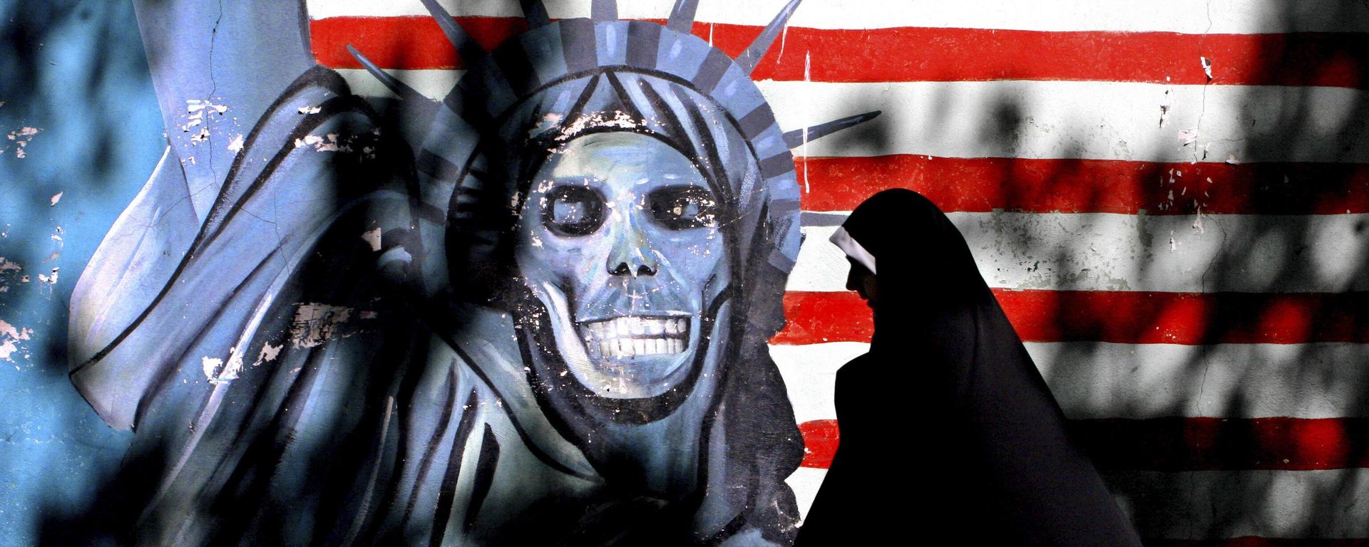 In this Sept. 25, 2007, file photo, an Iranian woman walks past graffiti art characterizing the U.S. Statue of Liberty, painted on the wall of the former U.S. Embassy in Tehran, Iran In this Sept. 25, 2007, file photo, an Iranian woman walks past graffiti art characterizing the U.S. Statue of Liberty, painted on the wall of the former U.S. Embassy in Tehran, Iran - Sputnik International, 1920, 15.08.2024