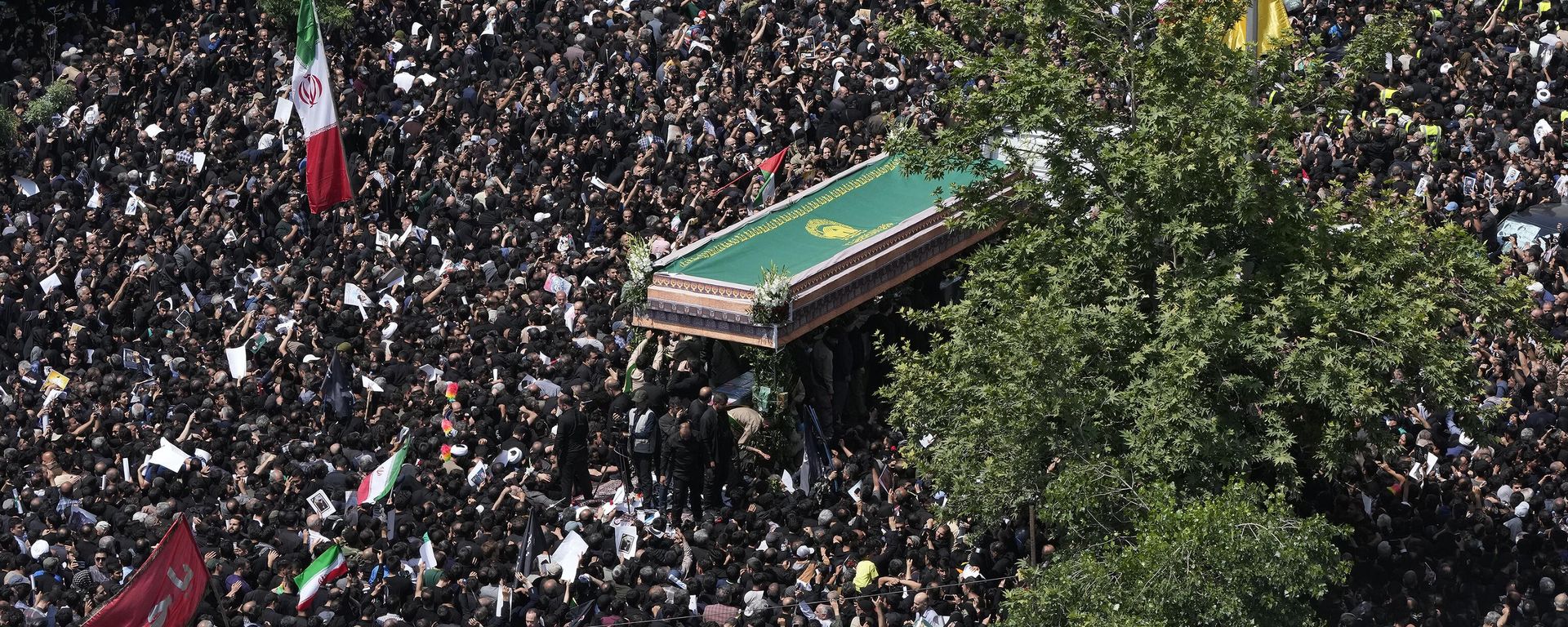 Iranians follow a truck carrying coffins of the late President Ebrahim Raisi and his companions who were killed in a helicopter crash on Sunday in a mountainous region of the country's northwest, during a funeral ceremony for them in Tehran, Iran, Wednesday, May 22, 2024. - Sputnik International, 1920, 22.05.2024
