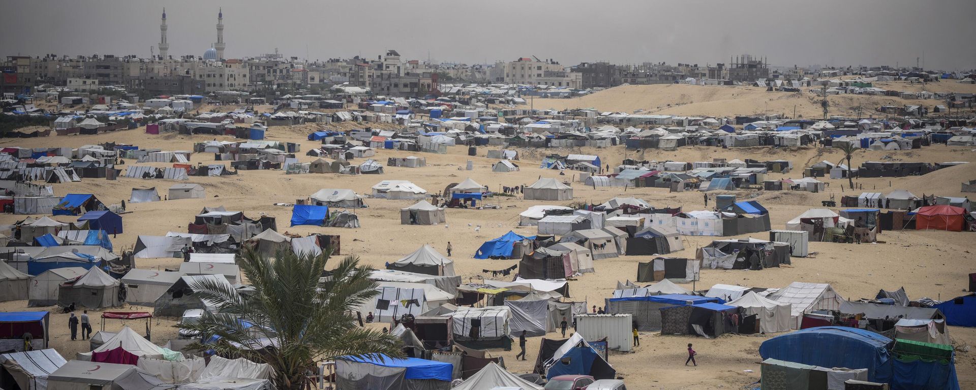Palestinians displaced by the Israeli air and ground offensive on the Gaza Strip walk through a makeshift tent camp in Rafah, Gaza, Friday, May 10, 2024. (AP Photo/Abdel Kareem Hana) - Sputnik International, 1920, 28.06.2024