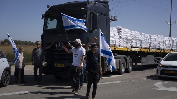 Holding Israeli flags people stand in front of trucks carrying humanitarian aid as they try to stop them from entering the Gaza Strip in an area near the Kerem Shalom border crossing in southern Israel, Thursday, May 9, 2024. (AP Photo/Leo Correa) Holding Israeli flags people stand in front of trucks carrying humanitarian aid as they try to stop them from entering the Gaza Strip in an area near the Kerem Shalom border crossing in southern Israel, Thursday, May 9, 2024. (AP Photo/Leo Correa) - Sputnik International