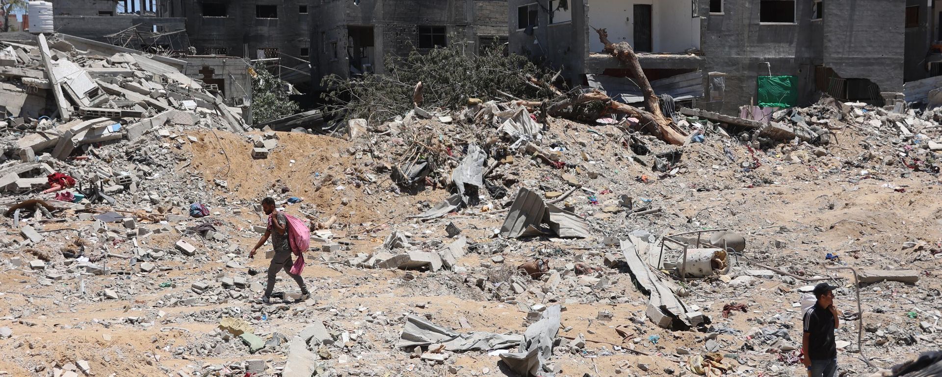Palestinians walks next to destroyed buildings in the Jabalia refugee camp in the northern Gaza on June 1, 2024.  - Sputnik International, 1920, 13.06.2024