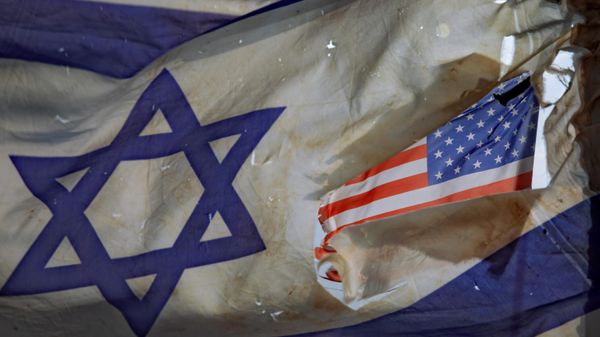 A US flag is seen through a hole torn in an Israel national flag, as they wave in the wind at a horse ranch, near the southern Israeli town of Sderot, Friday, Nov. 20, 2020 - Sputnik International