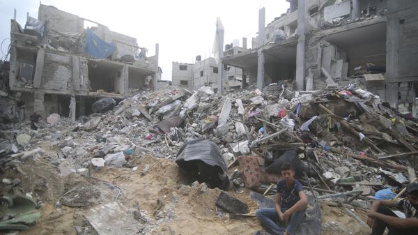 Palestinians sit by the rubble Abu Helal family in Rafah refugee camp, Gaza Strip, Monday, Oct. 9, 2023. The strike killed dozens of people - Sputnik International