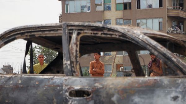Locals view a vehicle damaged by a rocket attack in Kabul, Afghanistan. Rockets struck a neighborhood near Kabul's international airport on Monday amid the ongoing US withdrawal from Afghanistan. - Sputnik International
