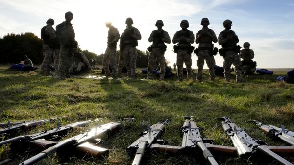 Weapons lie on the ground as Ukrainian personnel take a break during training  - Sputnik International