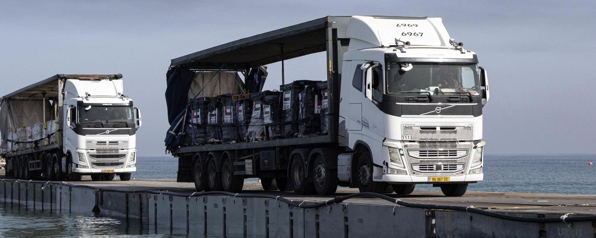 Trucks loaded with humanitarian aid from the United Arab Emirates and the United States Agency for International Development cross the Trident Pier before arriving on the beach on the Gaza Strip, May 17, 2024.  - Sputnik International, 1920, 23.06.2024