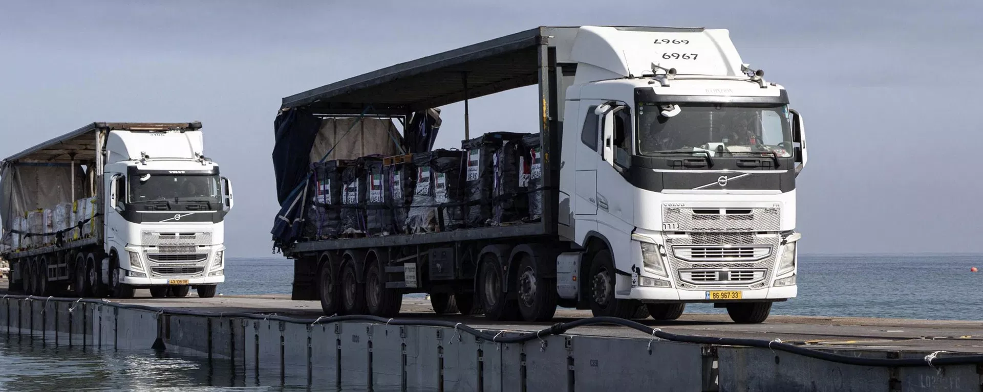 Trucks loaded with humanitarian aid from the United Arab Emirates and the United States Agency for International Development cross the Trident Pier before arriving on the beach on the Gaza Strip, May 17, 2024. - Sputnik International, 1920, 08.09.2026