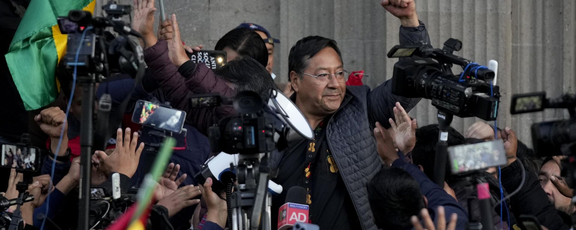 Bolivian President Luis Arce raises a clenched fist surrounded by supporters and media, outside the government palace in La Paz, Bolivia, Wednesday, June 26, 2024 - Sputnik International, 1920, 27.06.2024