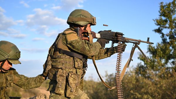 A Russian serviceman shoots a machine gun - Sputnik International