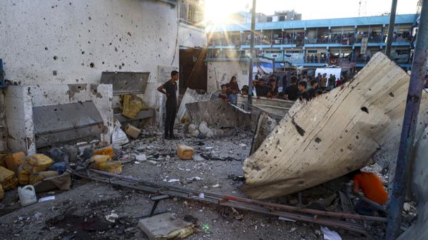 Palestinians look at the aftermath of the Israeli airstrike on a U.N.-run school–turned-shelter that killed at least 16 in the Nusseirat refugee camp in the Gaza Strip, Saturday, July 6, 2024, according to Gaza’s Health Ministry. - Sputnik International