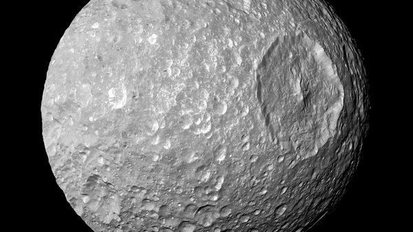 This Feb. 13, 2010 image provided by NASA shows Saturn's moon Mimas and it's large Herschel Crater, captured by the Cassini spacecraft. - Sputnik International