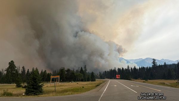 In this July 24, 2024, image obtained from the Jasper National Park in Canada, smoke rises from a wildfire burning in the park. The out of control wildfire has devoured up to half of the main town in western Canada's popular Jasper National Park, authorities said July 25, with 400 foreign firefighters called in to help battle the blaze.  - Sputnik International