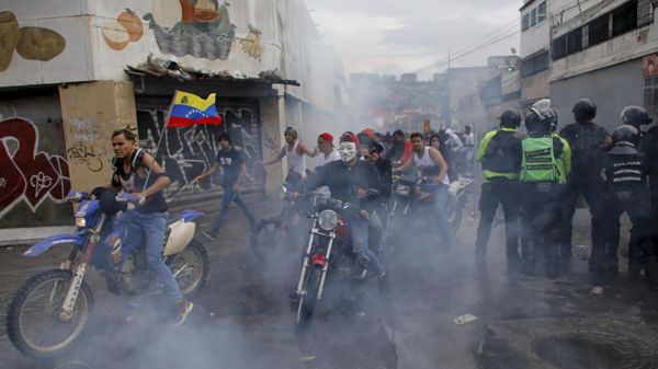 Protesters demonstrating against the official election results declaring President Nicolas Maduro's reelection ride through tear gas fired by police the day after the vote in Caracas, Venezuela, Monday, July 29, 2024. (AP Photo/Cristian Hernandez) - Sputnik International