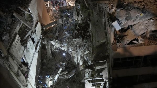 Civil defense workers check for victims between the wreckage of destroyed buildings that were hit by an Israeli airstrike in the southern suburbs of Beirut, Lebanon - Sputnik International
