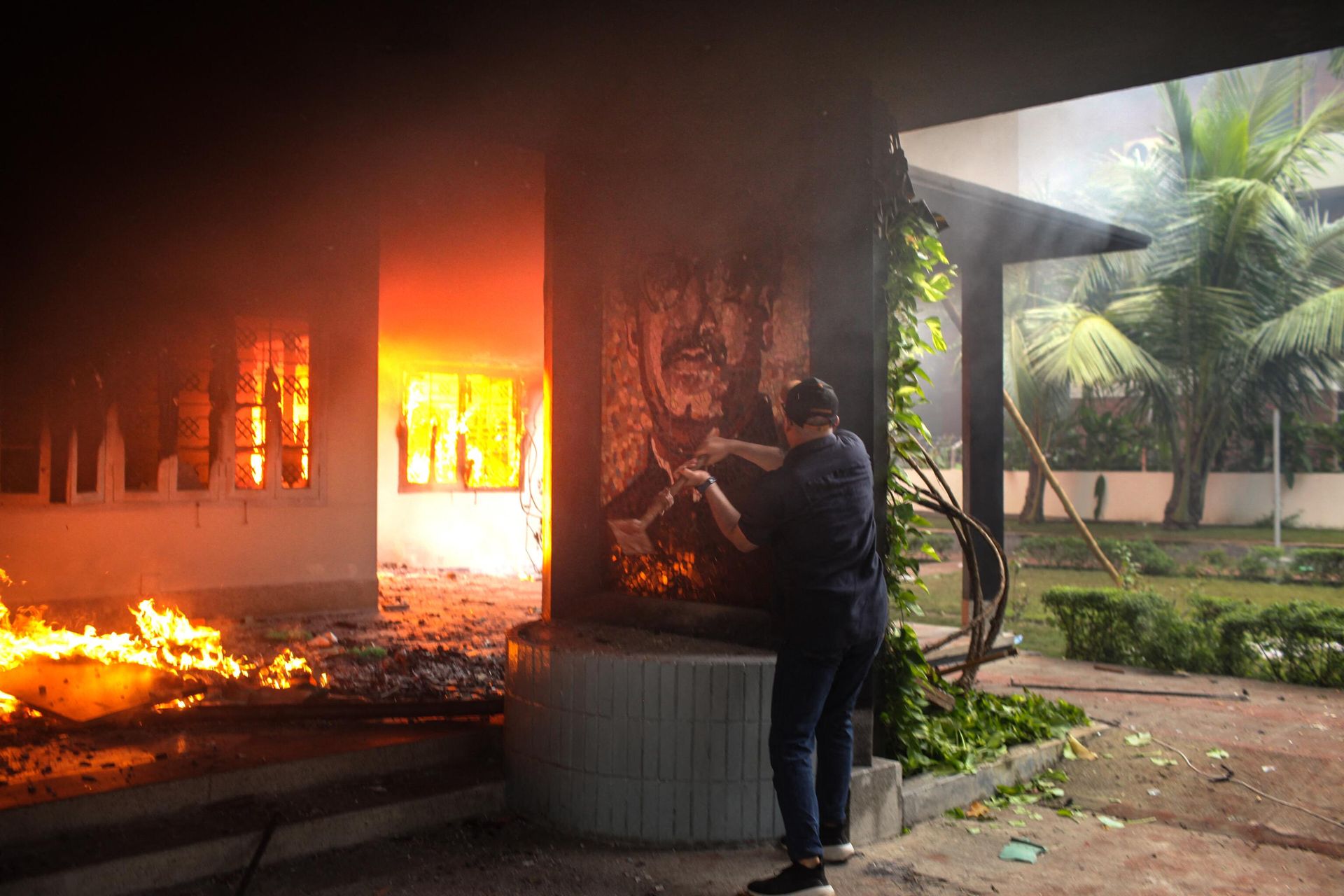 An anti-government protestor vandalises a portrait of Bangladesh's founding father Sheikh Mujibur Rahman as others set the Bangabandhu Memorial Museum on fire in Dhaka on August 5, 2024. An anti-government protestor vandalises a portrait of Bangladesh's founding father Sheikh Mujibur Rahman as others set the Bangabandhu Memorial Museum on fire in Dhaka on August 5, 2024. - Sputnik International, 1920, 05.08.2024