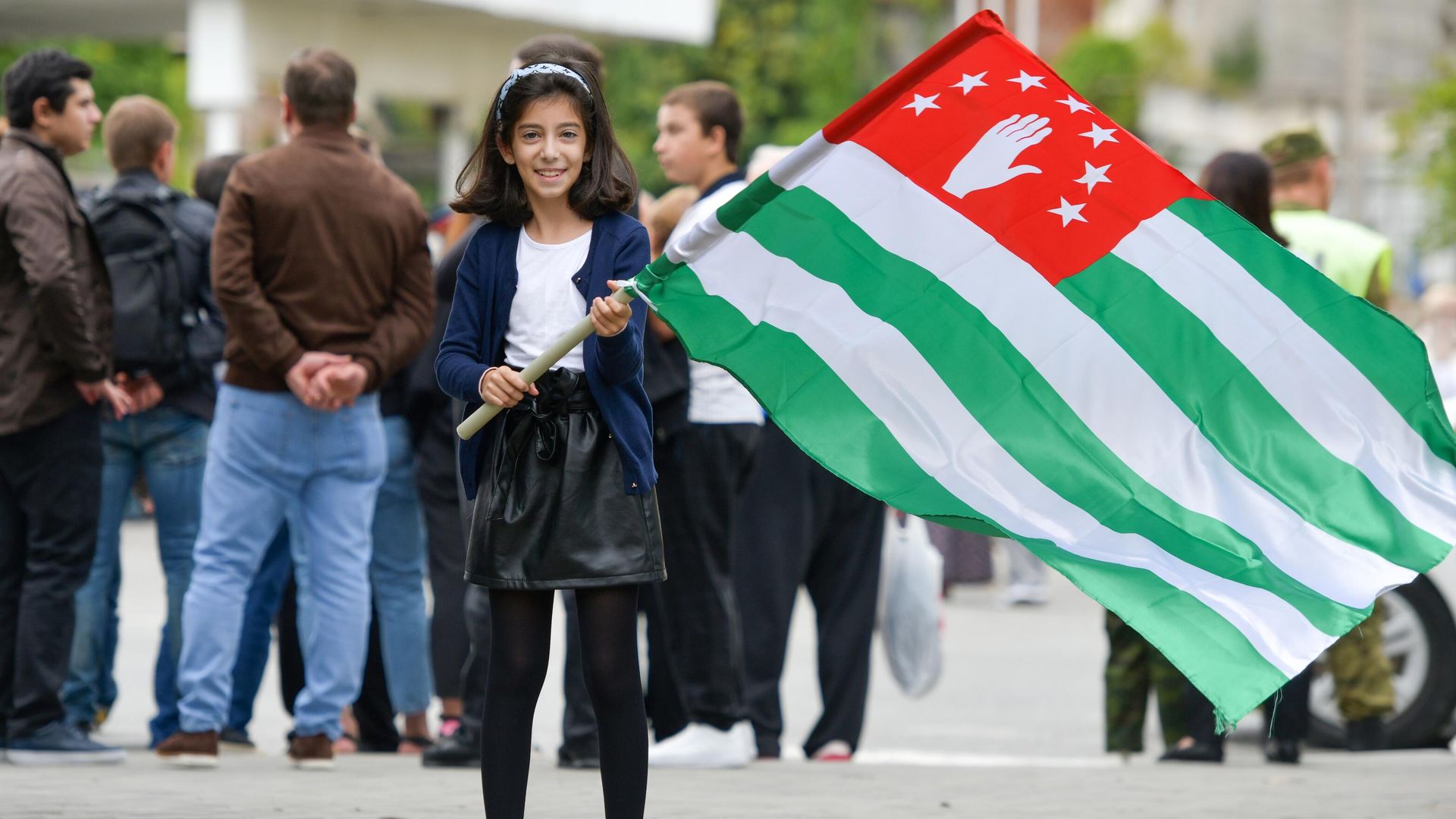 A girl holds the Abkhazian flag during celebrations of the Victory Day and the Independence Day of Abkhazia in Sukhum, Republic of Abkhazia. - Sputnik International, 1920, 08.08.2024
