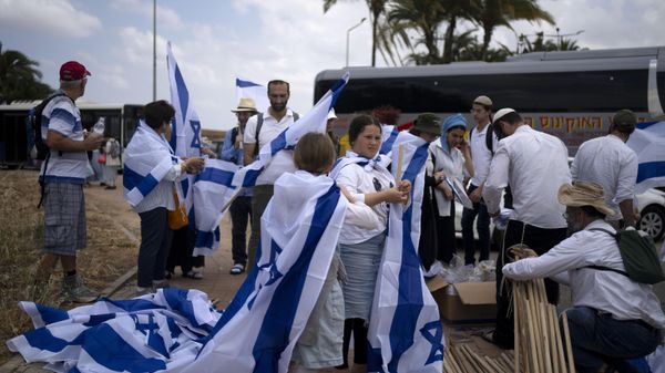 Israelis prepare national flags ahead of a march by thousands in the southern city of Sderot calling for the country to reoccupy the Gaza Strip once the war is over, Tuesday, May 14, 2024 - Sputnik International
