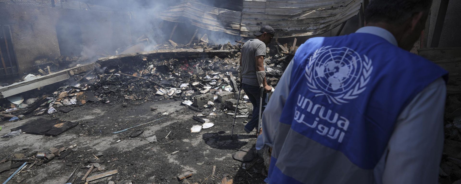 Palestinians look at the destruction after an Israeli strike on a school run by UNRWA, the U.N. agency helping Palestinian refugees, in Nuseirat, Gaza Strip, May 14, 2024. Qatar and Saudi Arabia on Sunday, June 2, 2024 condemned an Israeli parliamentary bill that seeks to label UNRWA, the main provider of aid for Palestinians in Gaza, a terrorist group, joining a growing number of nations opposed to the proposal - Sputnik International, 1920, 02.09.2024