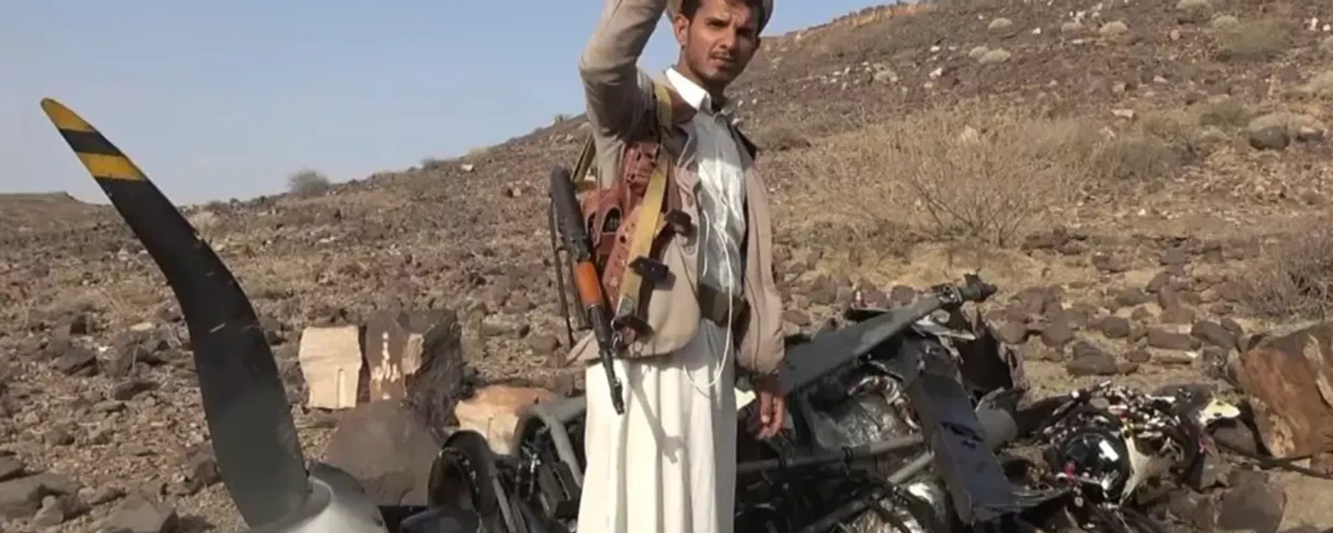 Houthi fighter poses in front of wreckage of US military MQ-9 Reaper drone shot down over Yemen. File photo. - Sputnik International, 1920, 17.10.2026