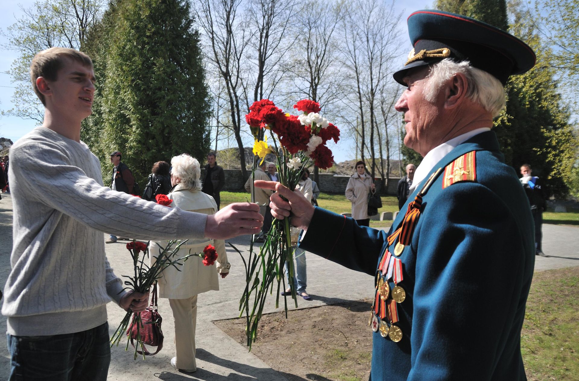 A young man gives a Great Patriotic War veteran flowers on May 9th at the Liberator Soldier monument (also known as the Bronze Soldier) located in a military cemetery in Tallinn, Estonia. A young man gives a Great Patriotic War veteran flowers on May 9th at the Liberator Soldier monument (also known as the Bronze Soldier) located in a military cemetery in Tallinn, Estonia. - Sputnik International, 1920, 22.09.2024