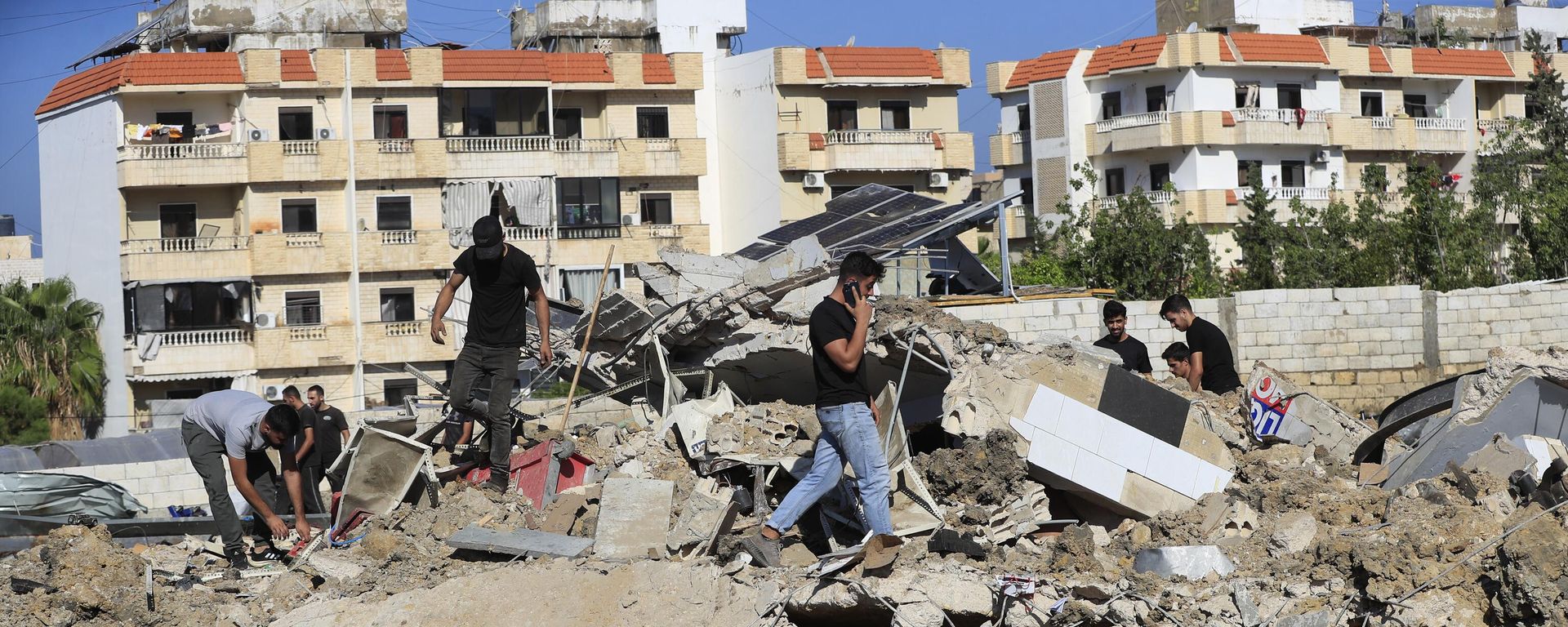 People gather at the site of an Israeli airstrike that hit a hangar in the southern town of Jiyeh, Lebanon, Wednesday, Sept. 25, 2024. People gather at the site of an Israeli airstrike that hit a hangar in the southern town of Jiyeh, Lebanon, Wednesday, Sept. 25, 2024. - Sputnik International, 1920, 29.09.2024